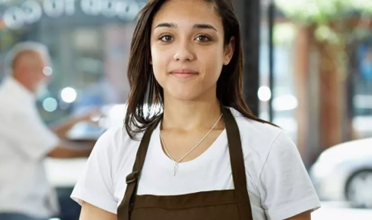 young girl with an apron on in a work environment