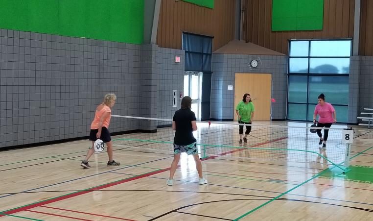 Two teams playing on a pickleball court