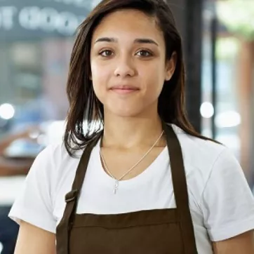 young girl with an apron on in a work environment