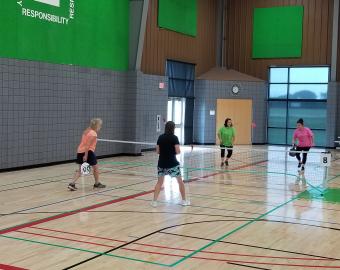 Two teams playing on a pickleball court